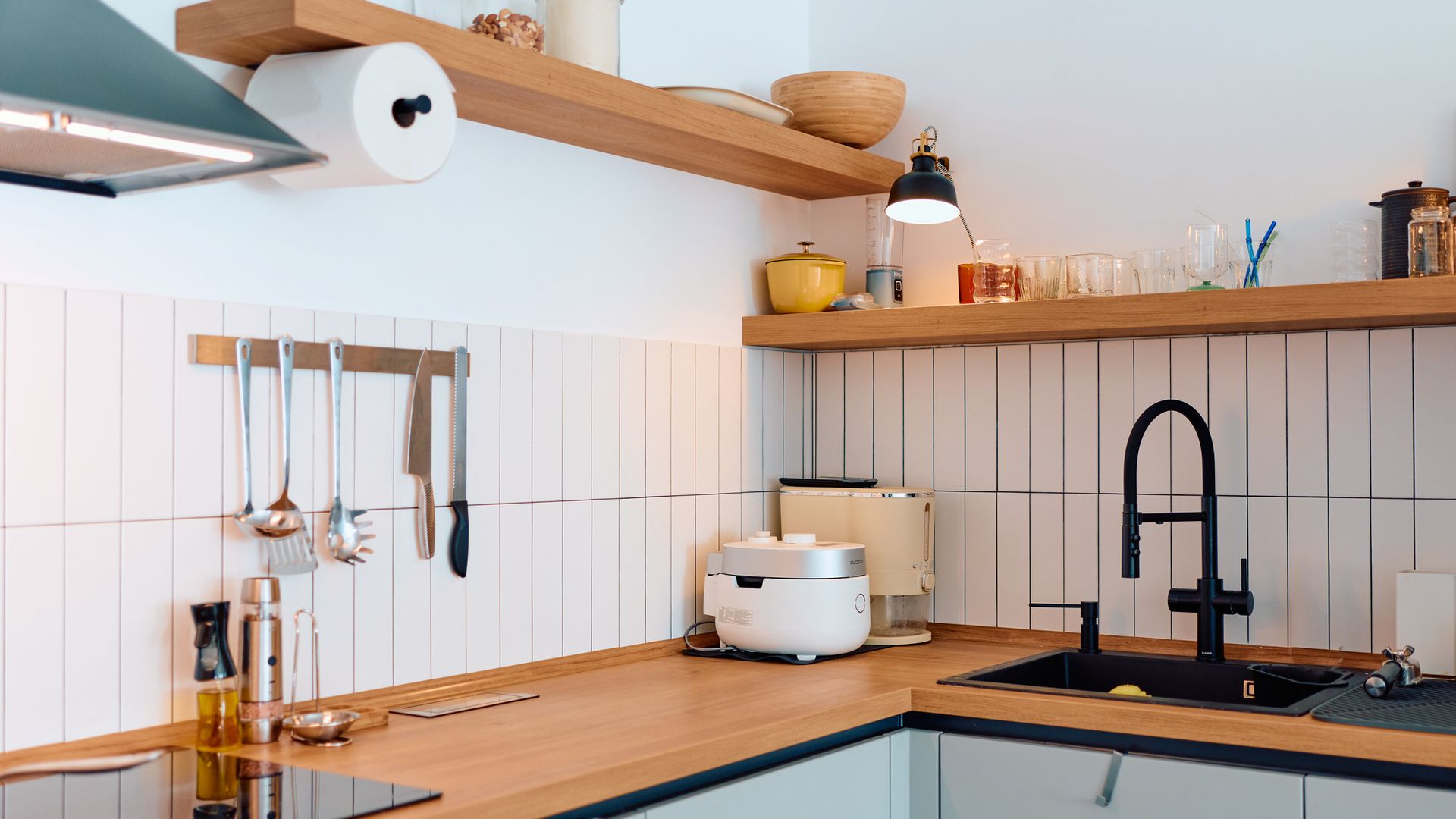 Cocina moderna con fregadero y encimera, en blanco y madera.