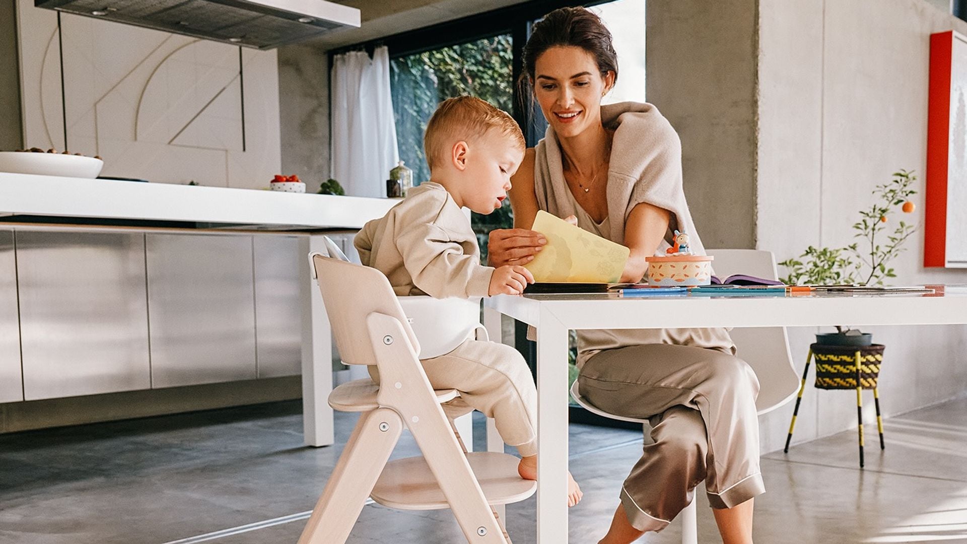 Madre con su bebé en una trona de Cybex, sentados a la mesa haciendo actividades.