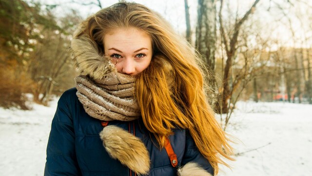 Mujer joven en invierno con cabello bonito y abrigo en la nieve
