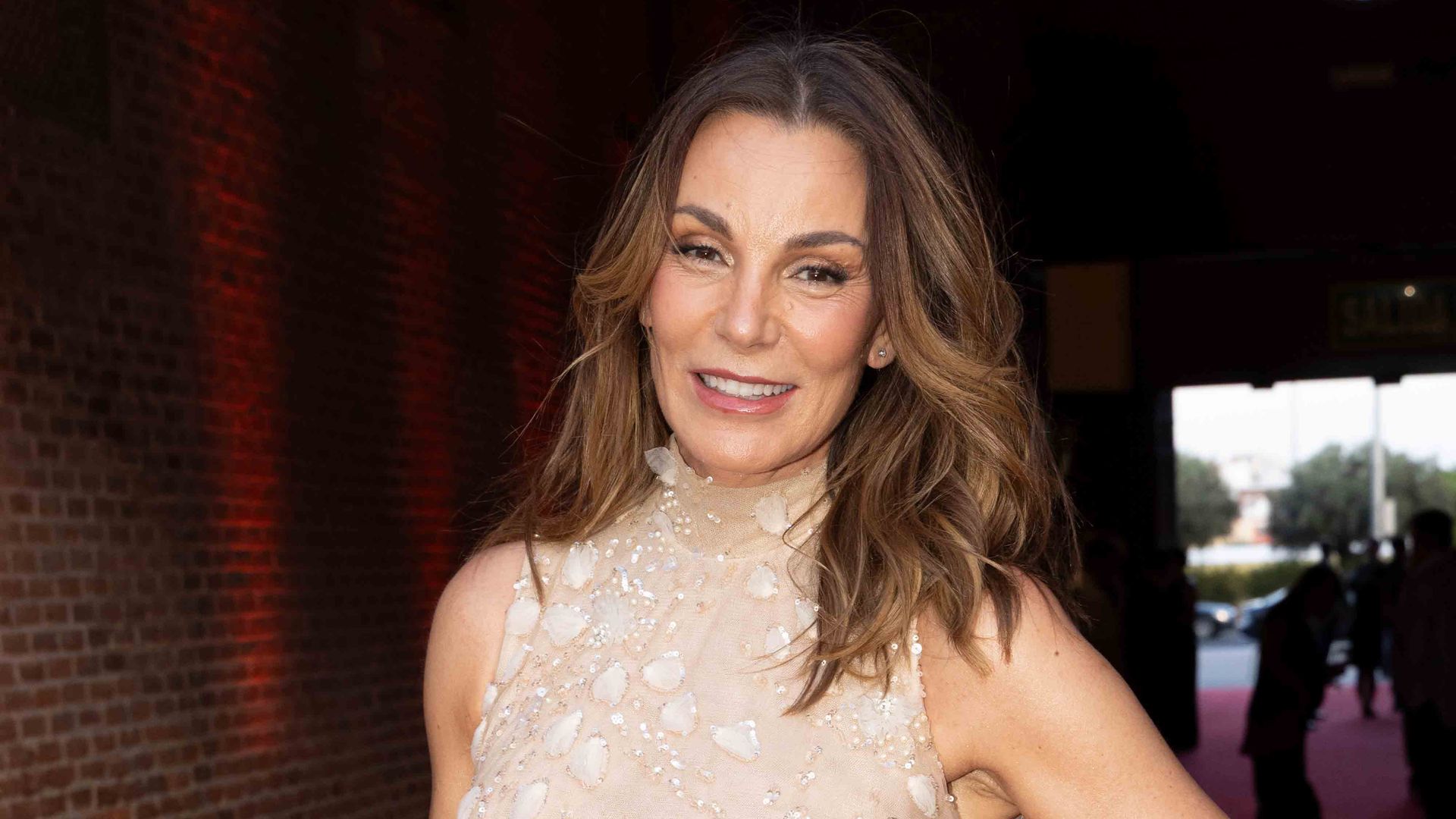 Mar flores con un vestido en tono coral para una gala 