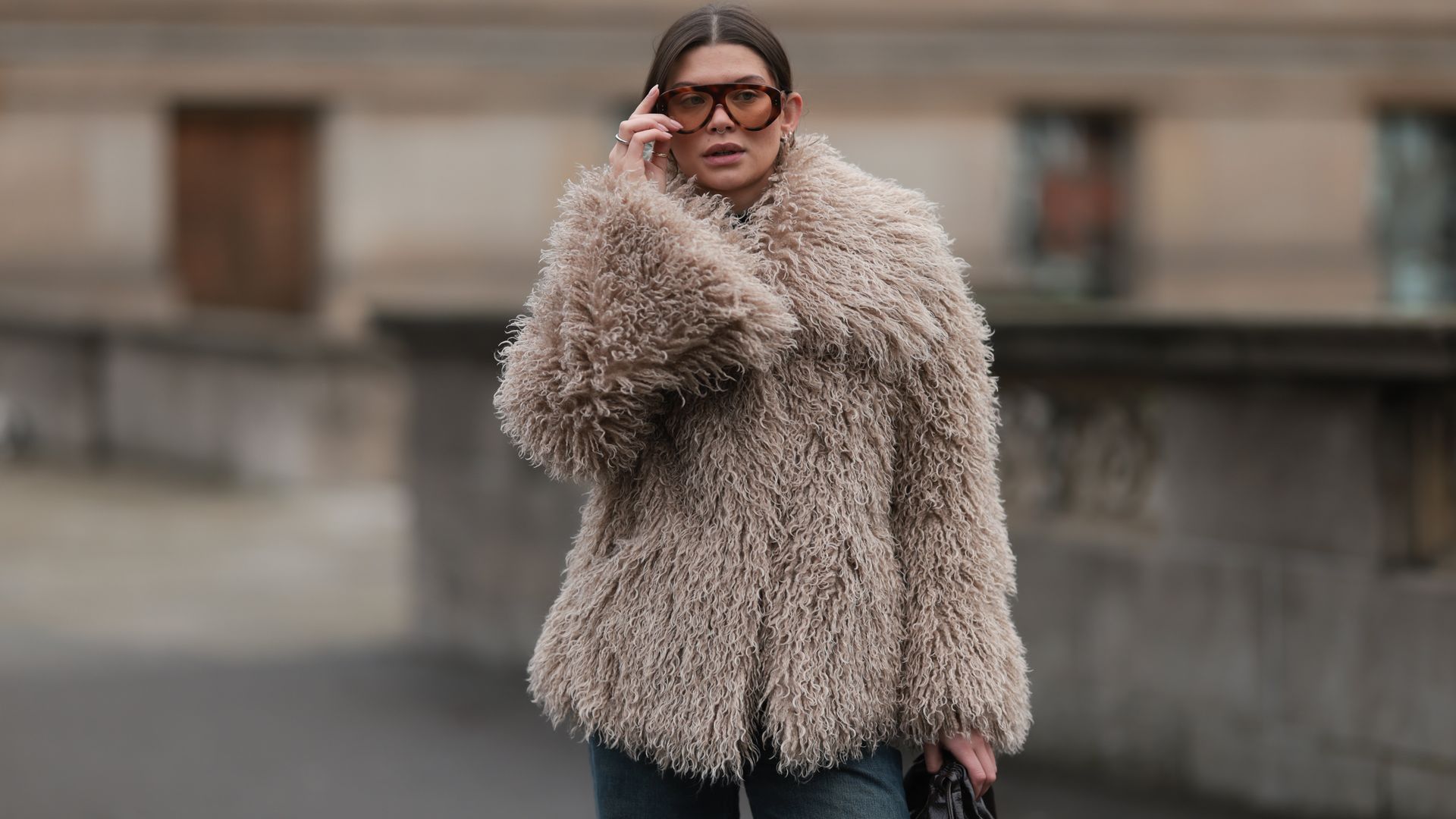 Sophia Geiss con abrigo de pelo beis, vaqueros y gafas de sol en Berlín