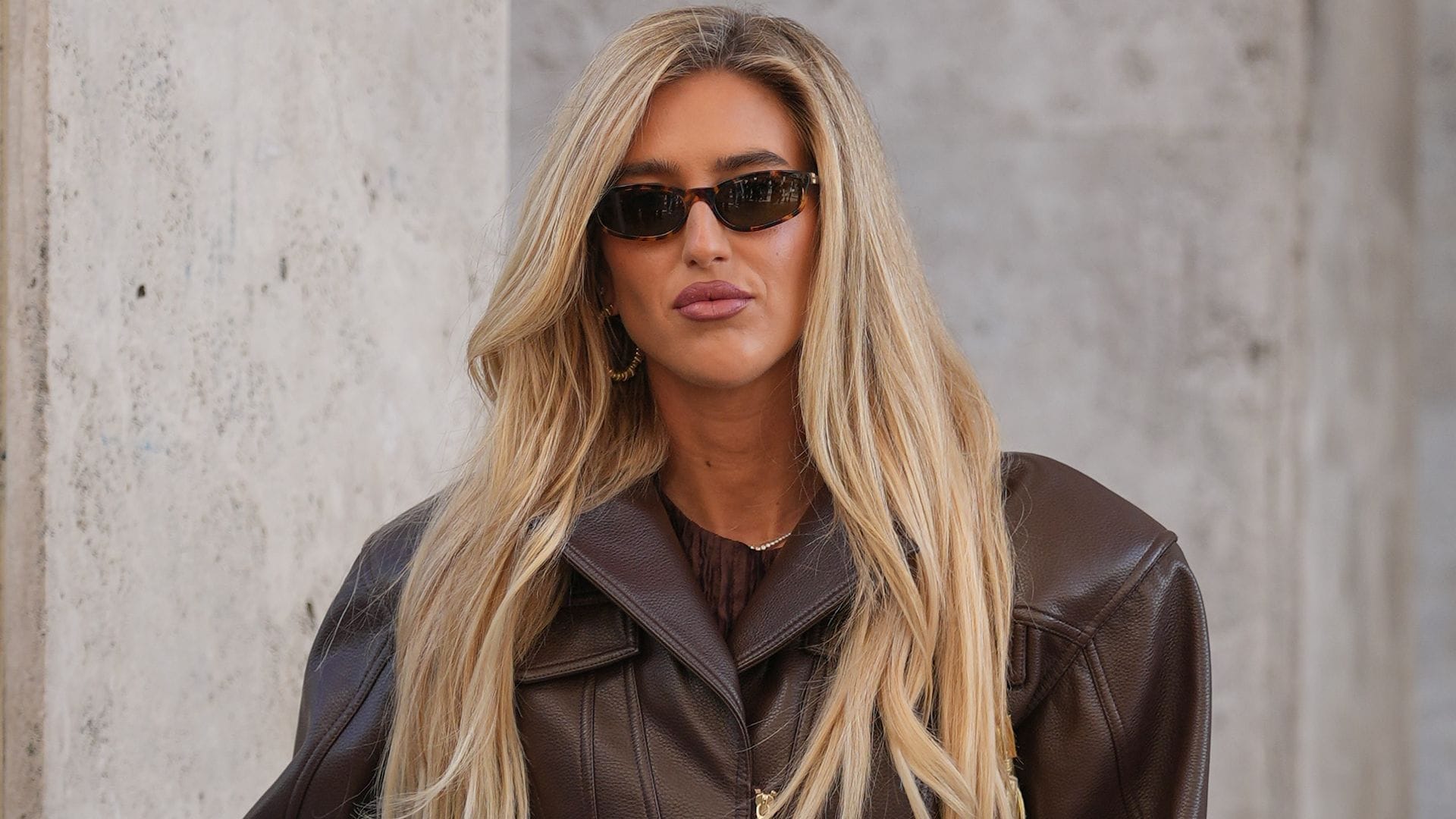 Emily Sindlev con pantalón blanco, blusa y cazadora marrón en París en 2025