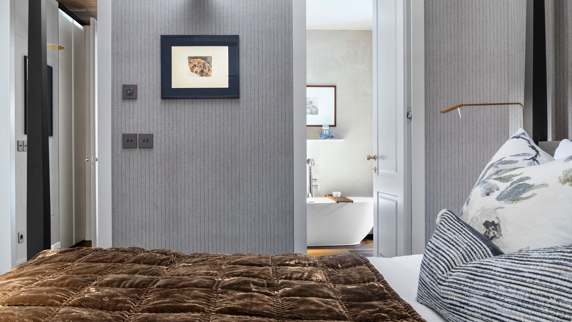 Dormitorio en suite con papel pintado gris, aplique de pared, cuadros