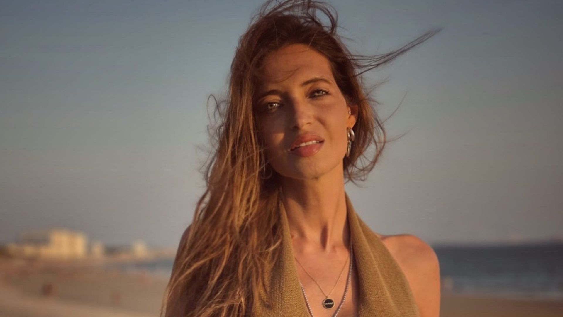 Sara Carbonero en la playa con conjunto en tonos tierra, el pelo despeinado y la piel bronceada