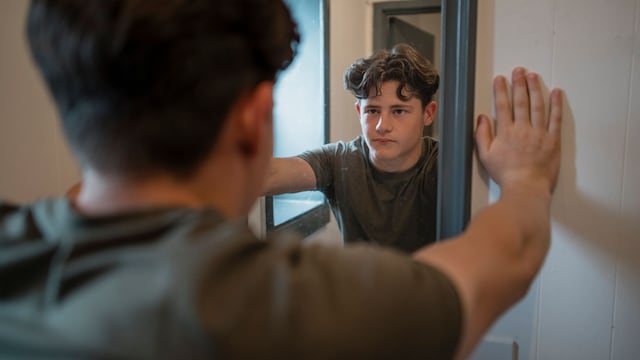 Adolescente serio frente al espejo