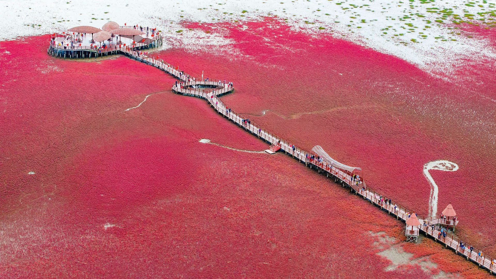 Vista aérea de un puente peatonal sobre un mar rojo con multitud de personas