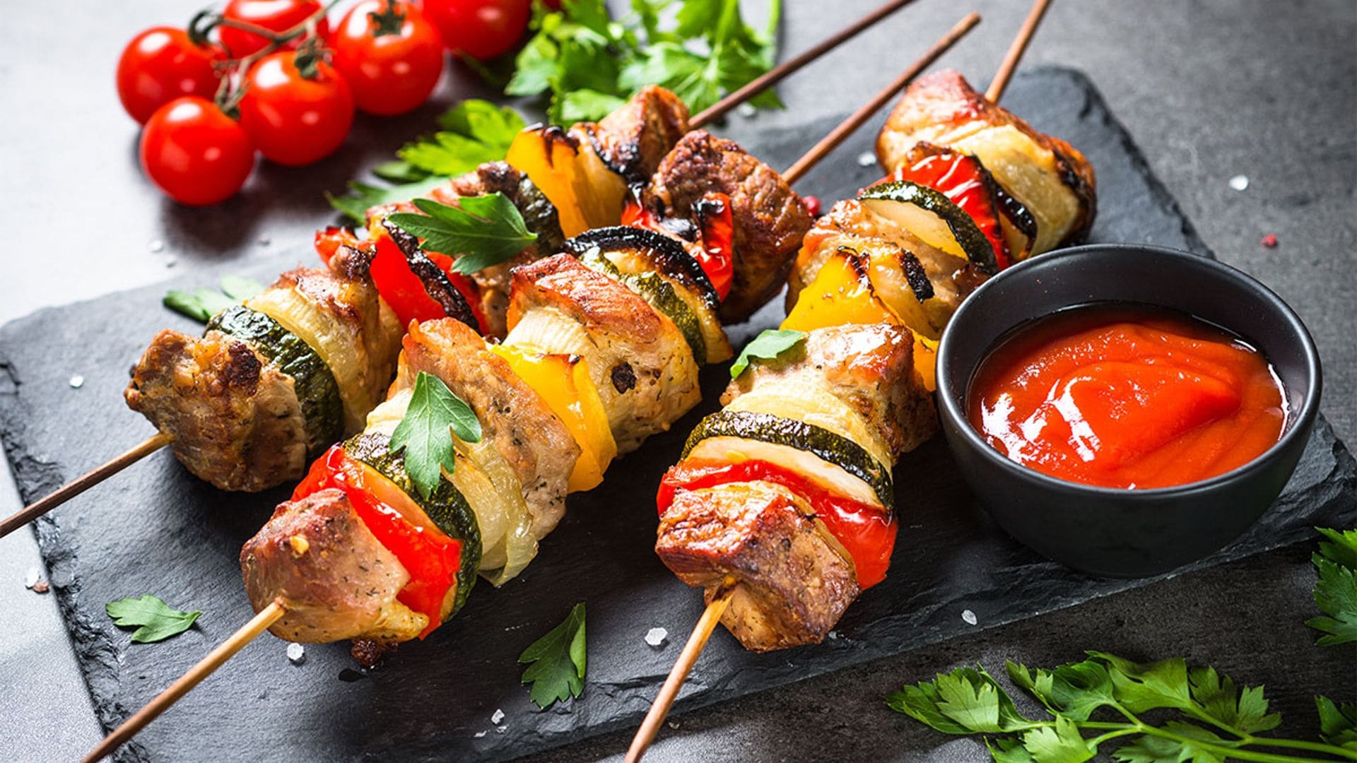 Brochetas de cerdo y verduras con salsa de tomate cherry