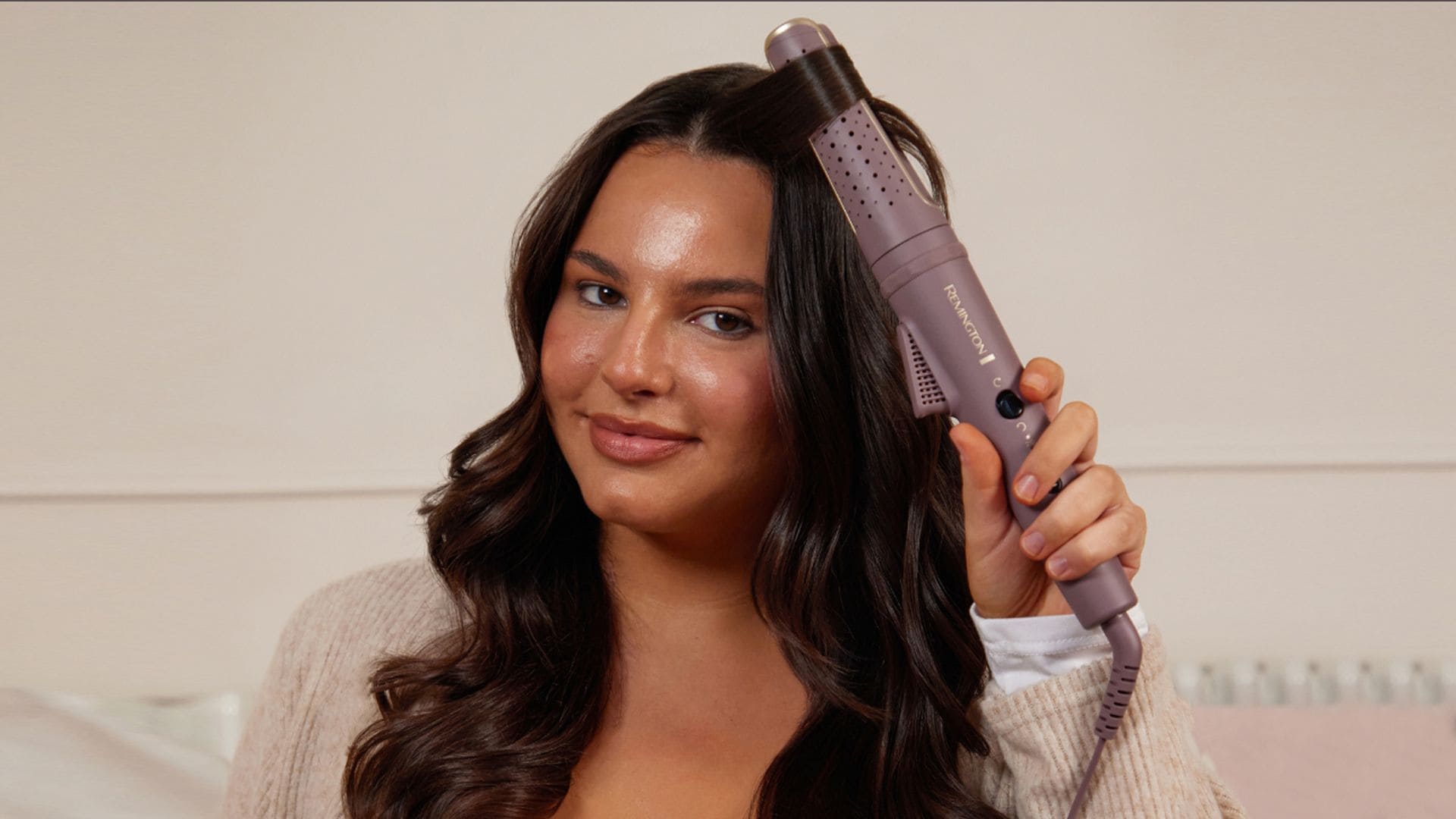 Mujer morena peinándose con rizador de pelo Airvive de Remington