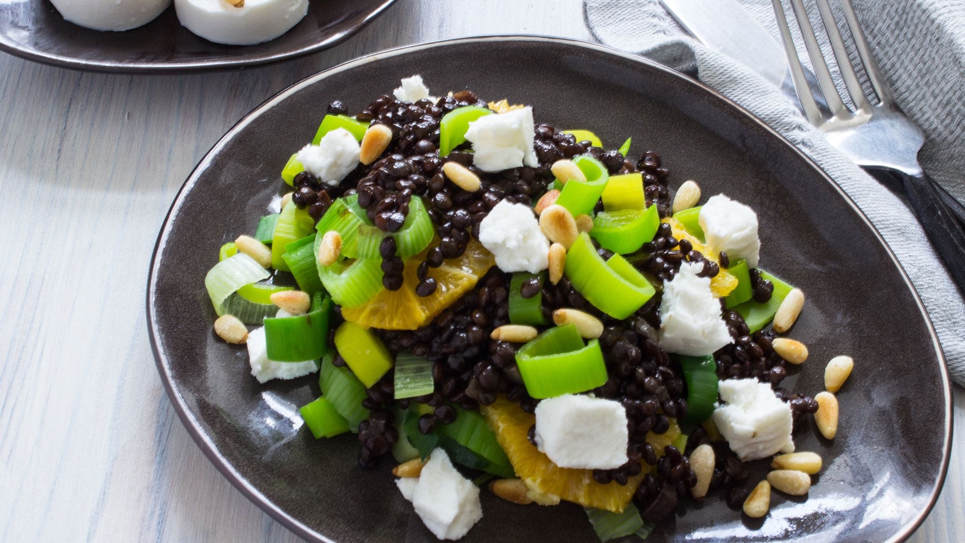 Ensalada de lentejas beluga con queso de cabra y naranja