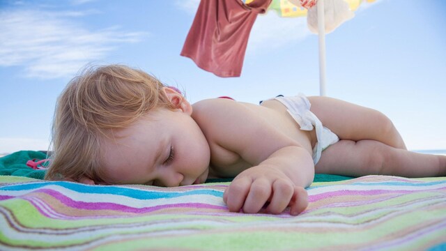beb durmiendo en la playa
