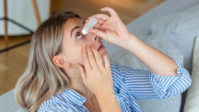 mujer aplicándose un colirio en el ojo
