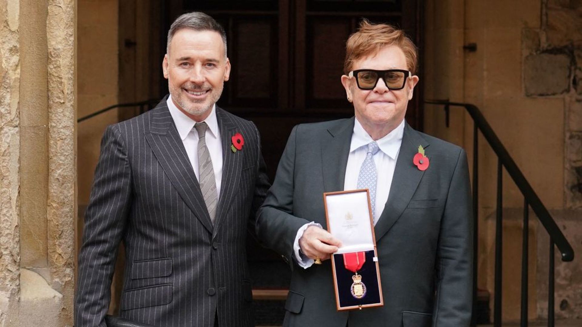 Elton John posa junto a su esposo David Furnish con su medalla tras ser nombrado miembro de la Orden de los Compañeros de Honor por sus servicios a la música y a la beneficencia en 2021