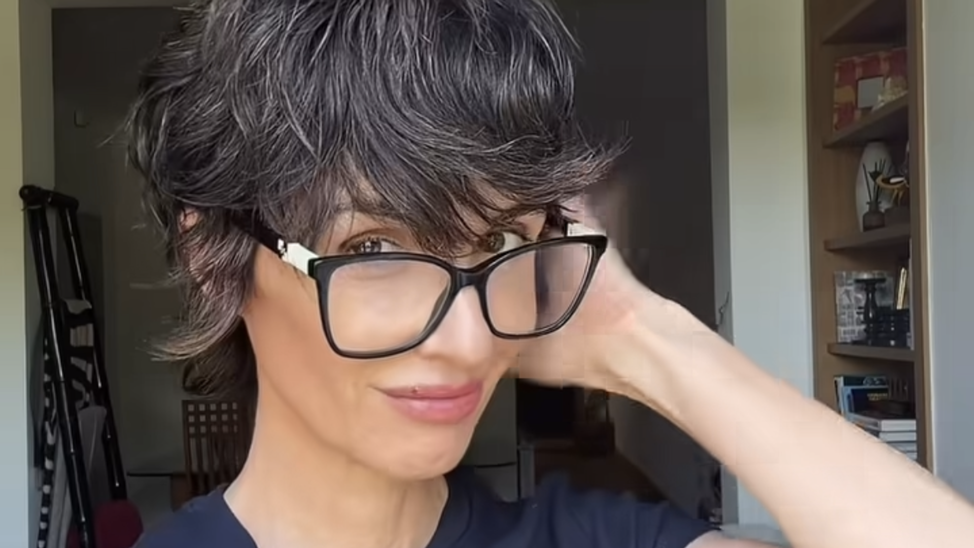 Paz Vega con camiseta azul, maxigafas de montura oscura y corte de pelo corto