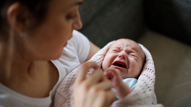 Recién nacida llora en brazos de su madre