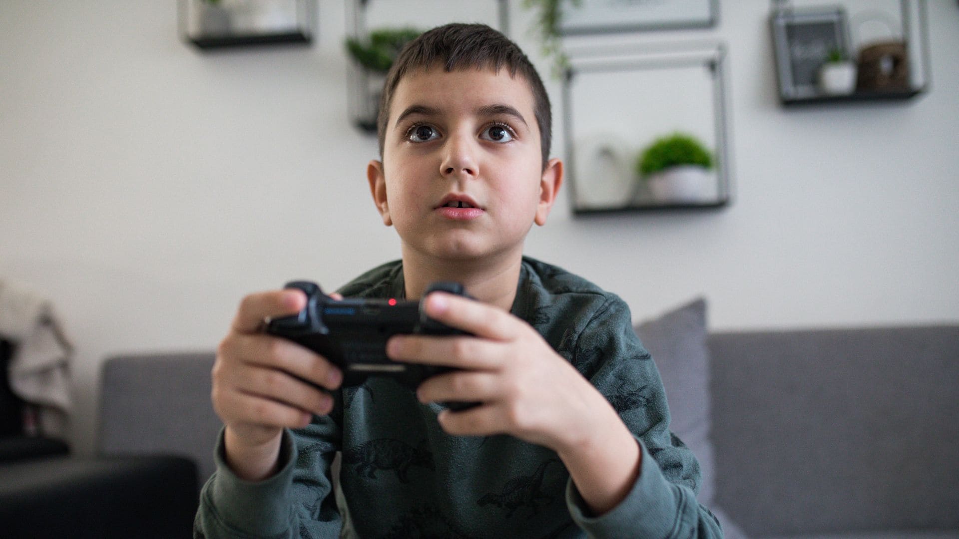 Niño juega a un videojuego en casa