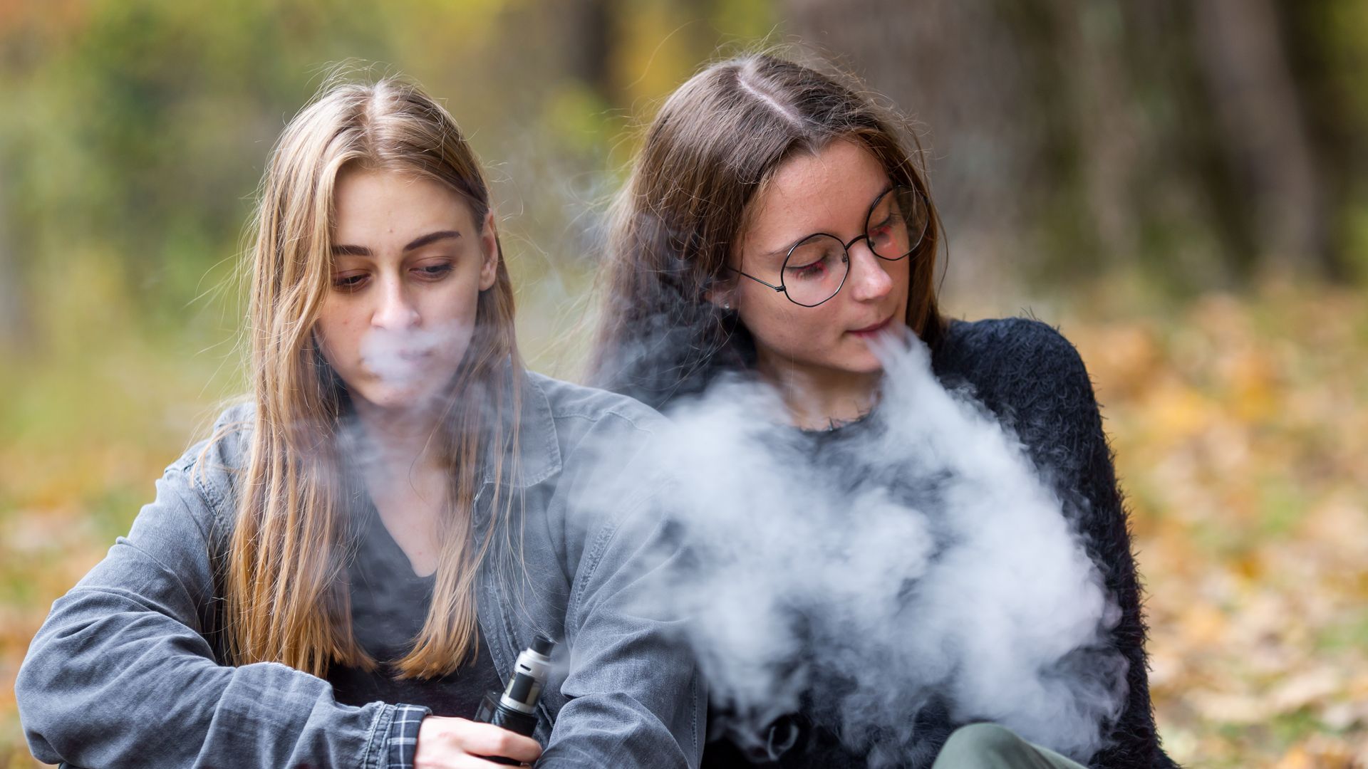 Dos adolescentes fumando vaper