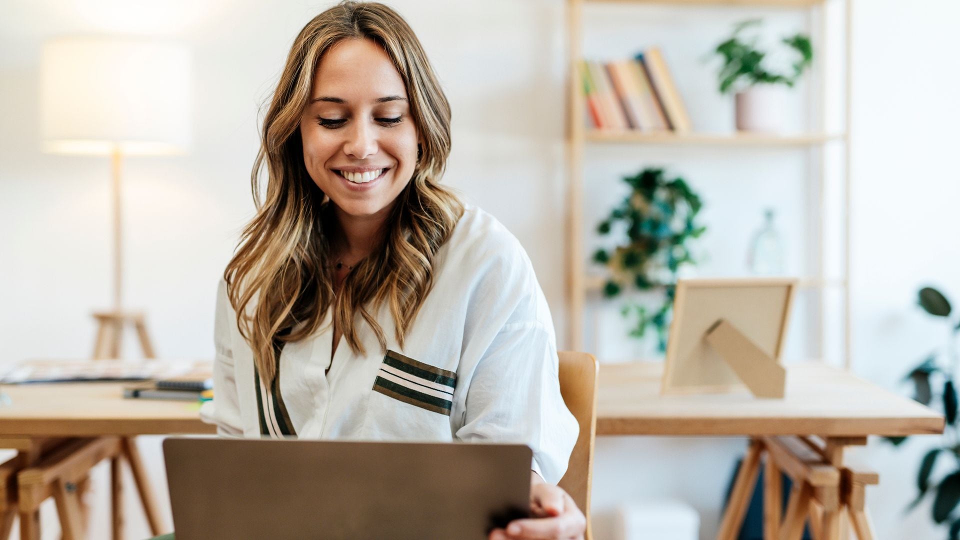 Mujer feliz en la oficina trabajando en su ordenador