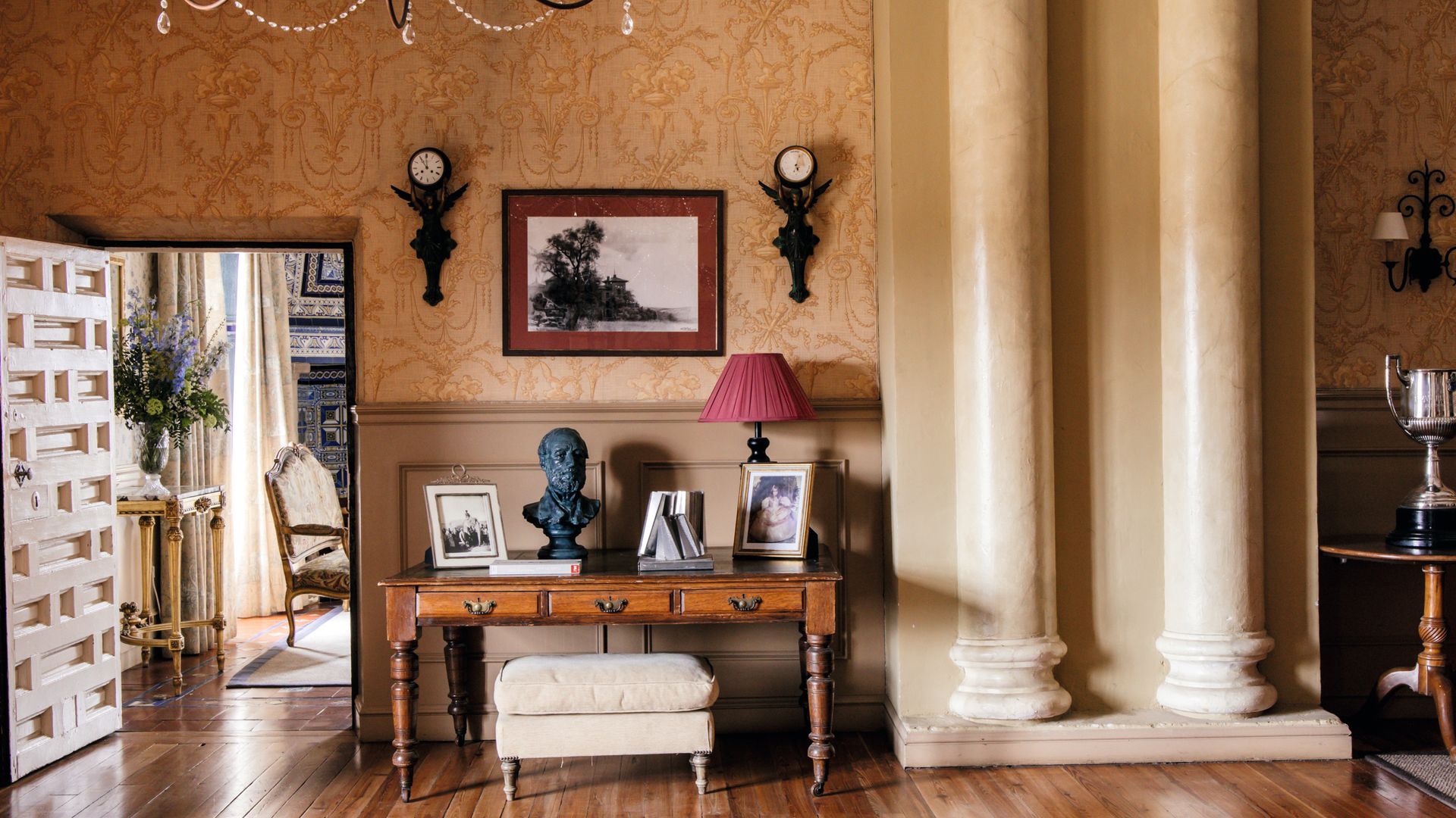 Uno de los espacio del interior del palacio, con mesa de madera y grandes columnas de mármol 