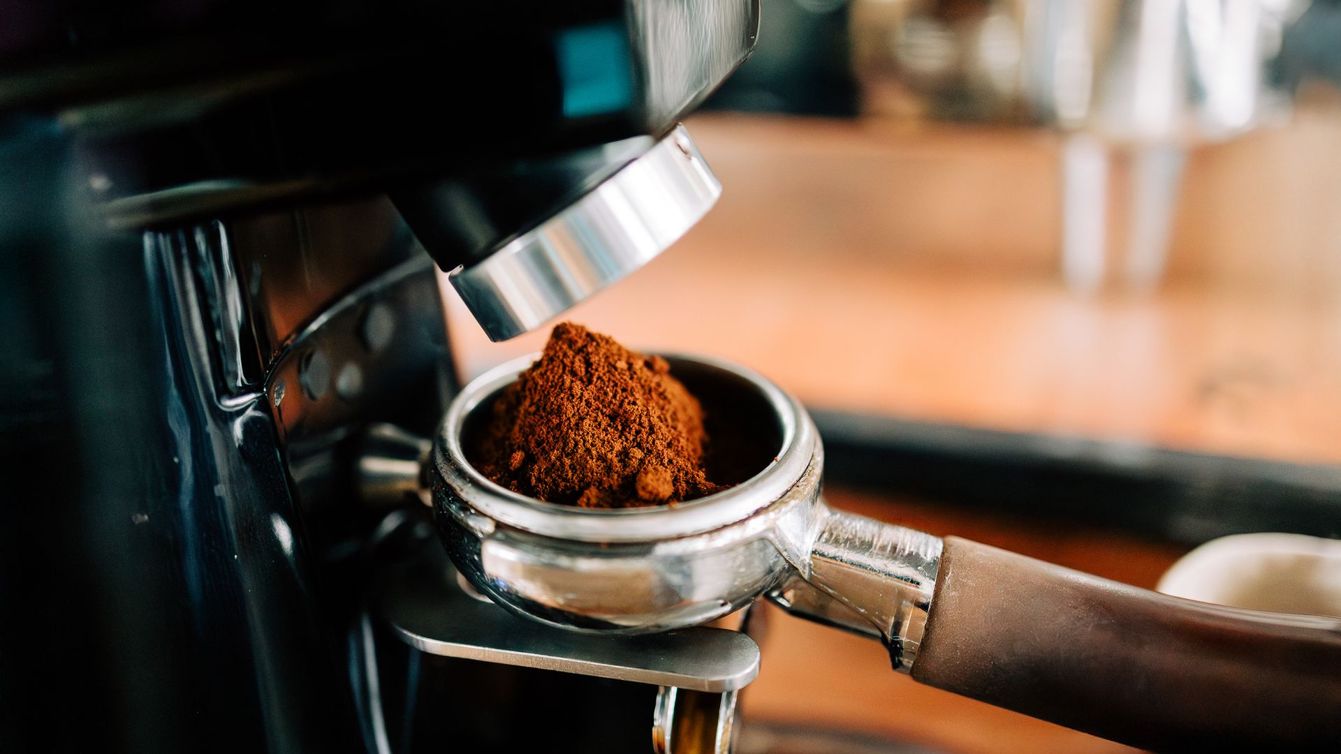 Cafetera de molinillo en primer plano, cargando café molido.