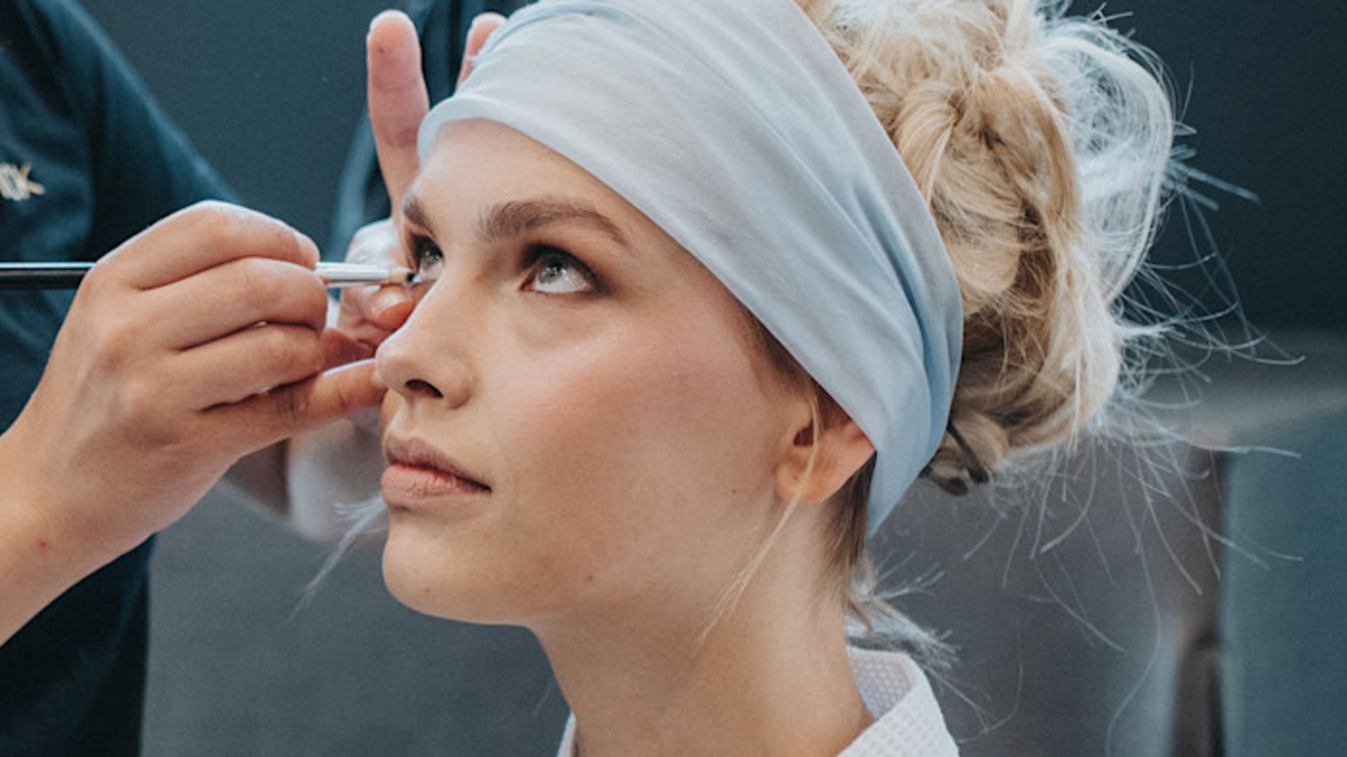 Modelo en el backstage del desfile de Yanina con cinta de pelo gris en la cabeza