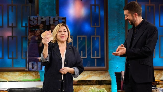 Plano medio de Carmen Machi en la Revuelta con David Broncano sujetando unos billetes