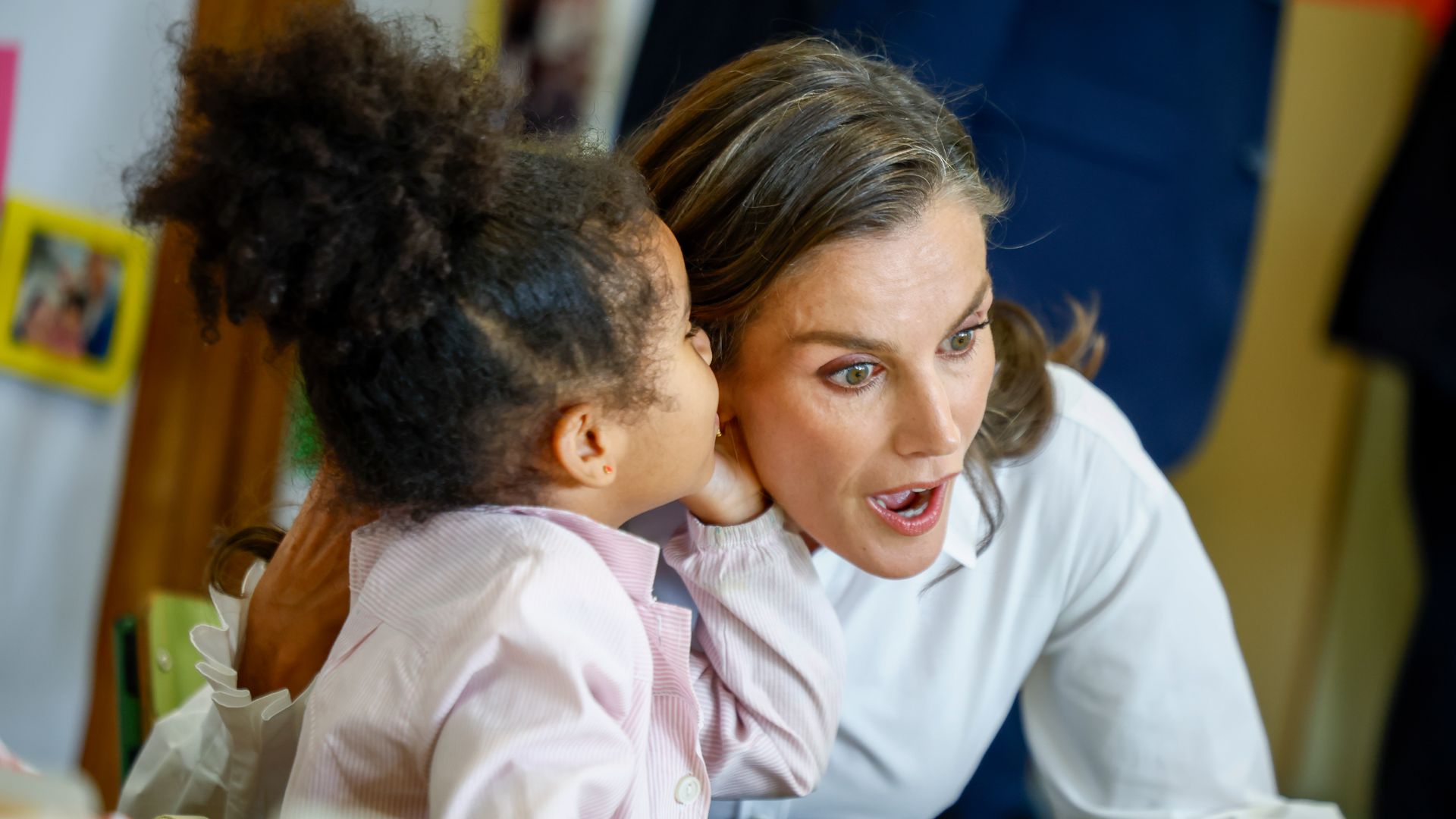 Gesto de asombro de la reina Letizia cuando una niña de infantil le cuenta un secreo al oido
