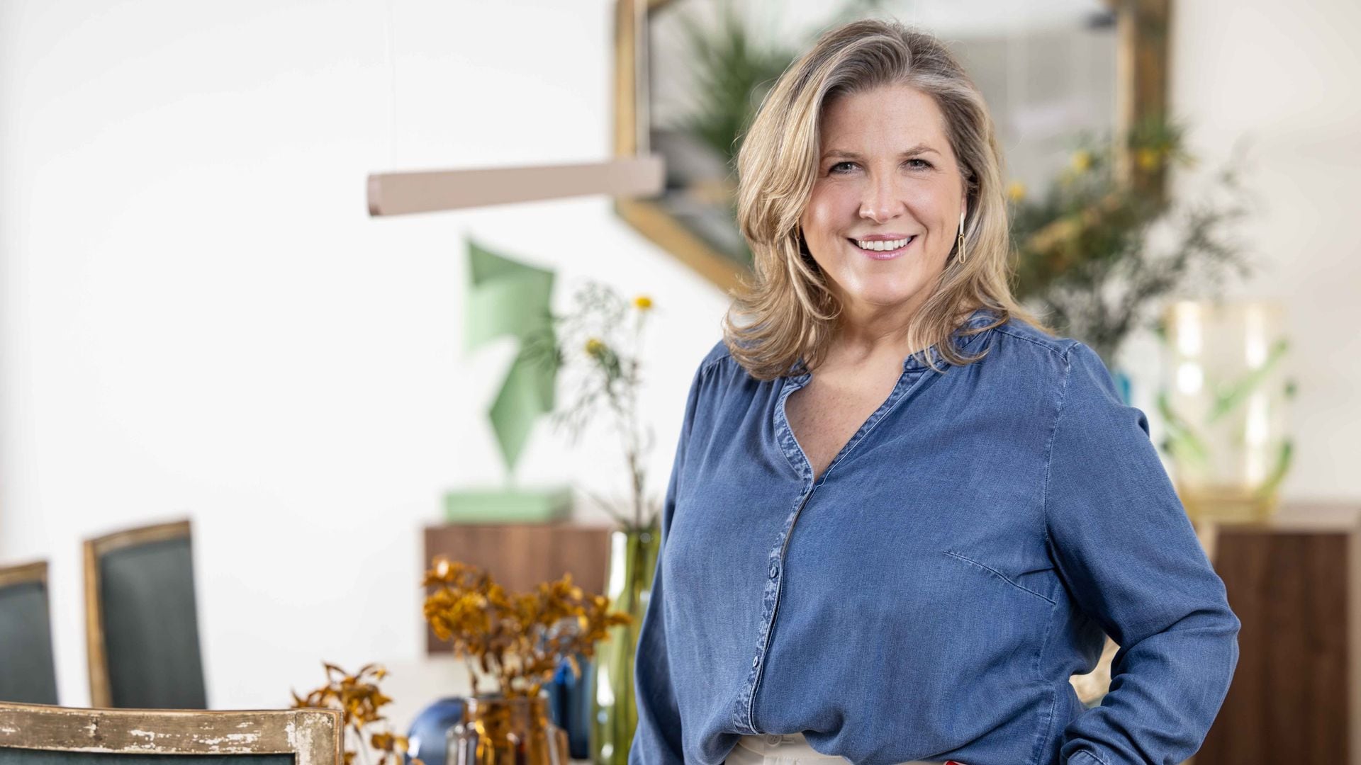 Retrato de la interiorista Silvia Trigueros delante de una mesa de comedor con jarrones