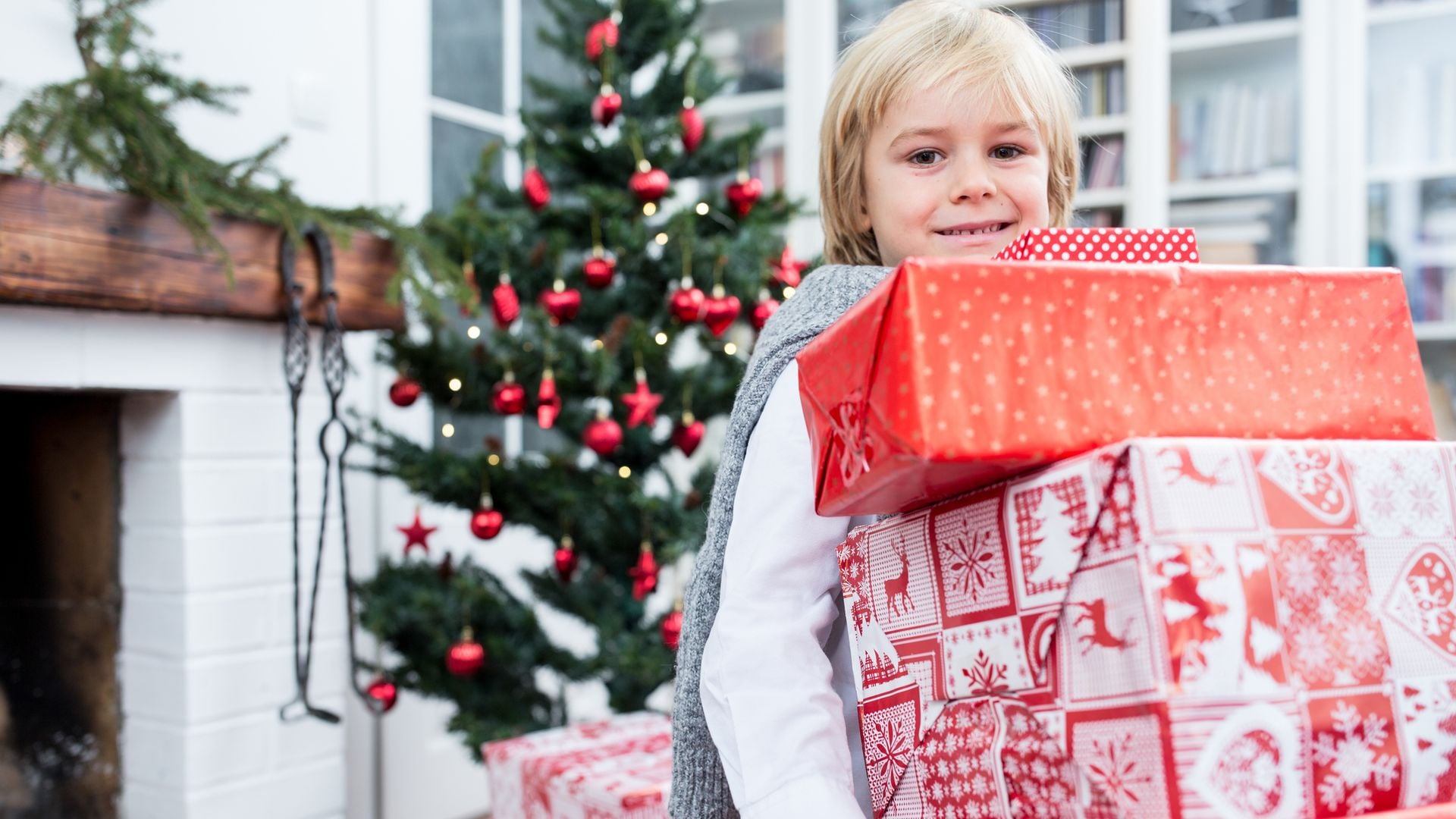 Niño con muchos regalos en Navidad
