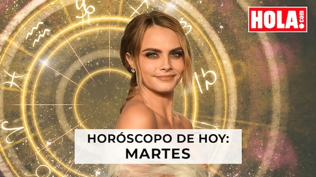 Cara Delevinge con la rueda del zodiaco detrás 