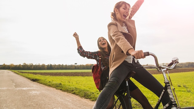 dos chicas felices montando en bicicleta