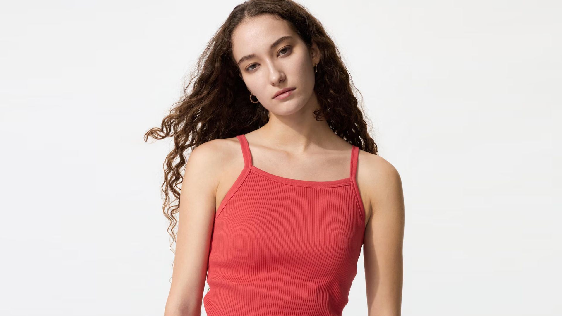Mujer morena con camiseta de tirantes con sujetador de Uniqlo en color coral
