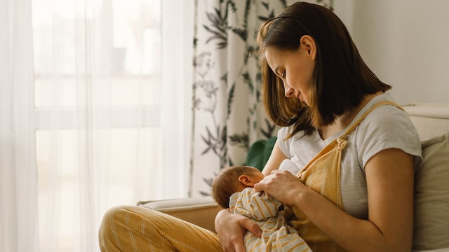 Madre da el pecho a su bebé recién nacido