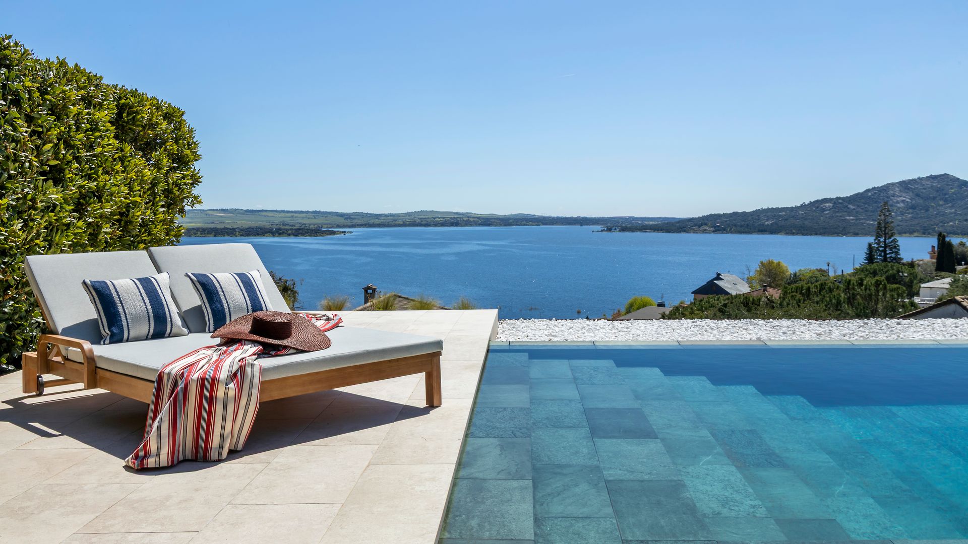 Piscina infinita con vistas al embalse, dos hamacas con cojines