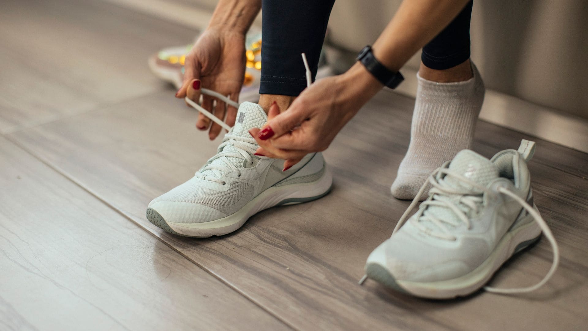 Mujer atándose los cordones de sus zapatillas de gimnasio