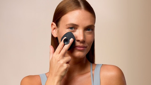 Rostro de mujer usando el cepillo limpiador facial de Geske