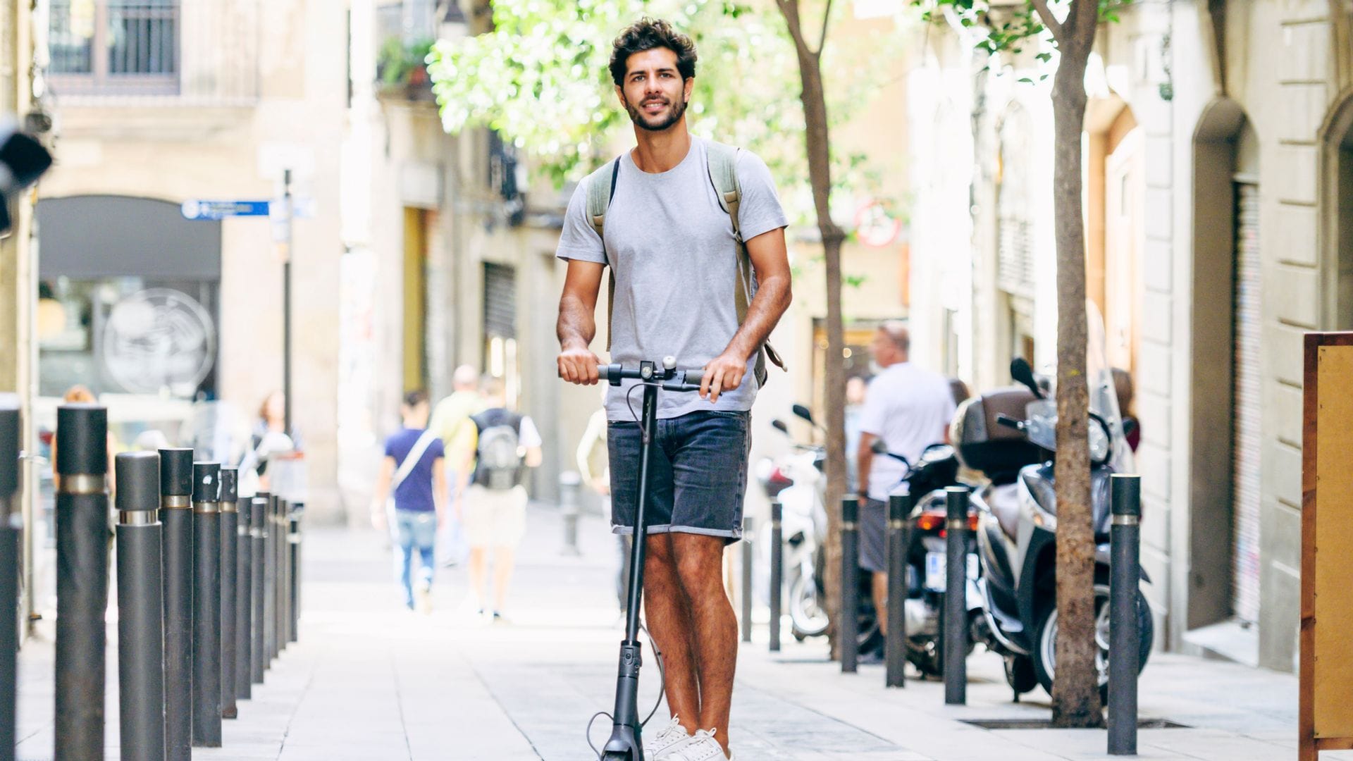 Un chico por las calles de Barcelona montado en un patinete eléctrico 