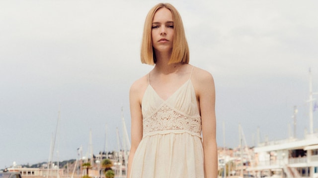 Mujer rubia con vestido blanco con crochet de Mango Outlet