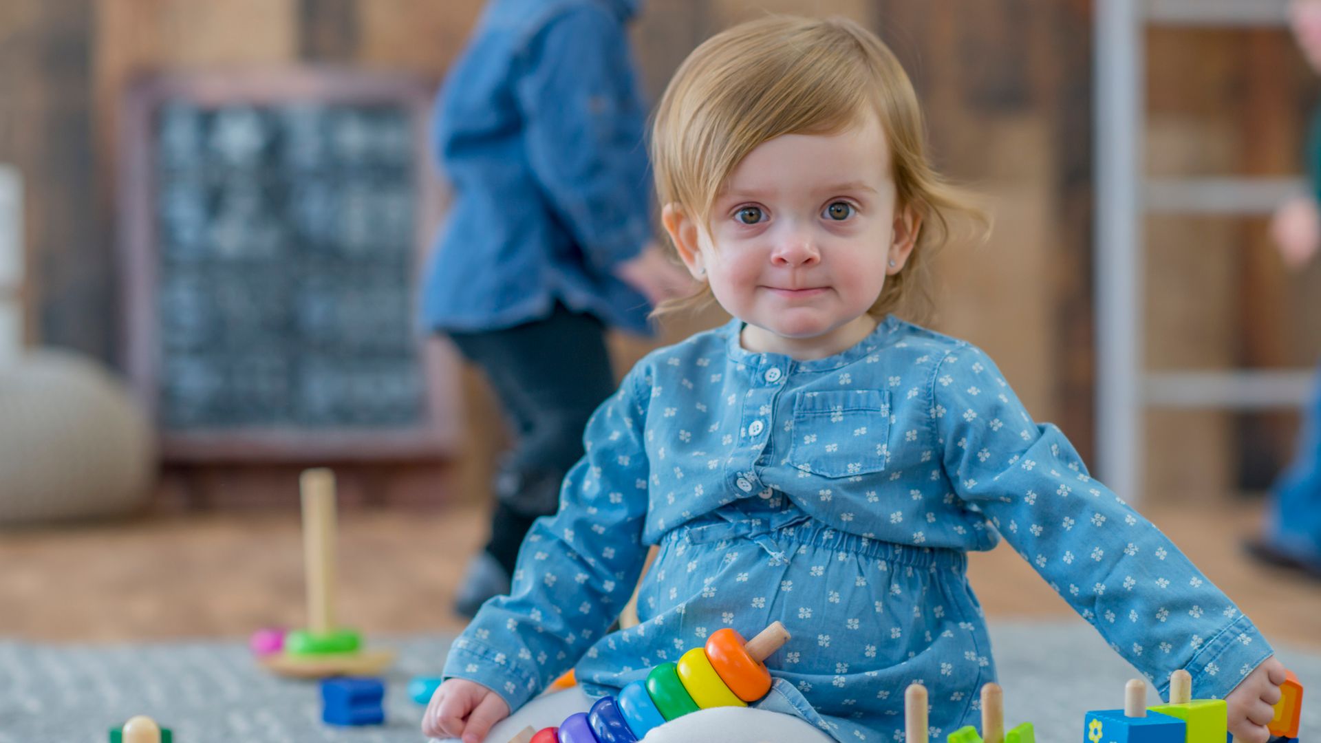 niña jugando en el suelo de la escuela infantil