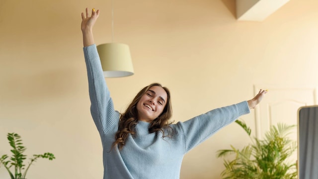 mujer relajada y feliz estirando los brazos
