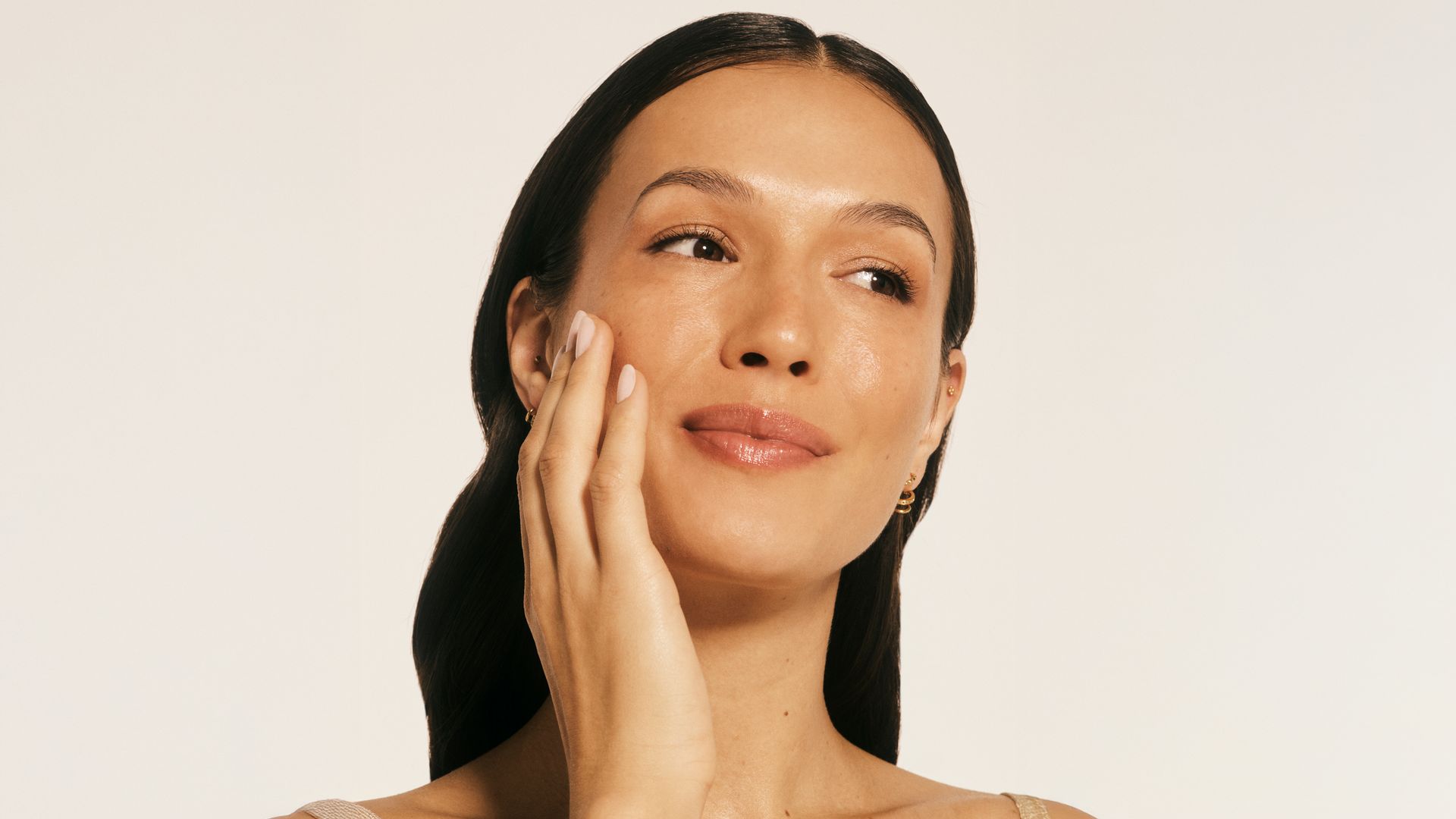 Rostro de mujer morena con piel jugosa y radiante