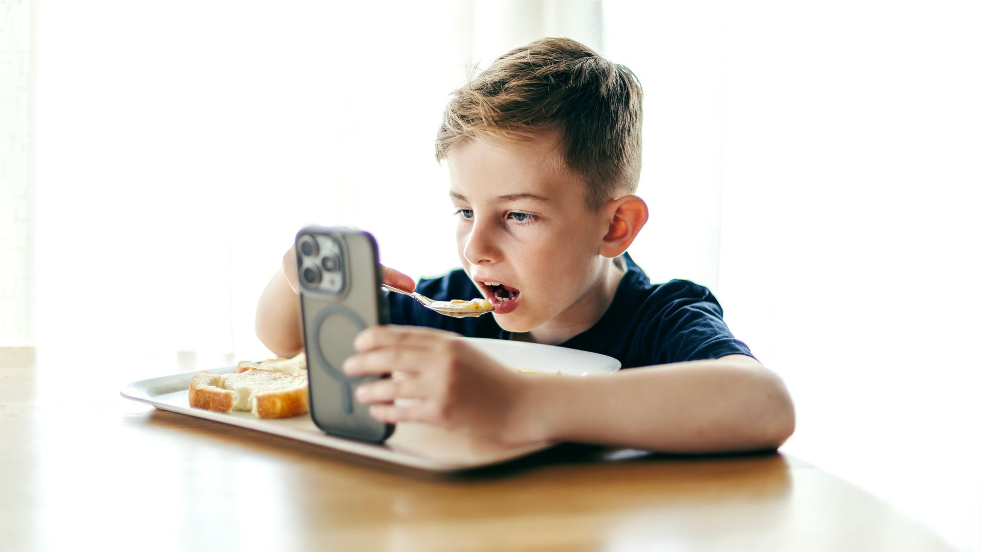 niños comiendo mientras mira el móvil