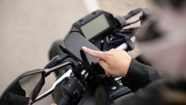 Una mujer usando un soporte de móvil para la moto