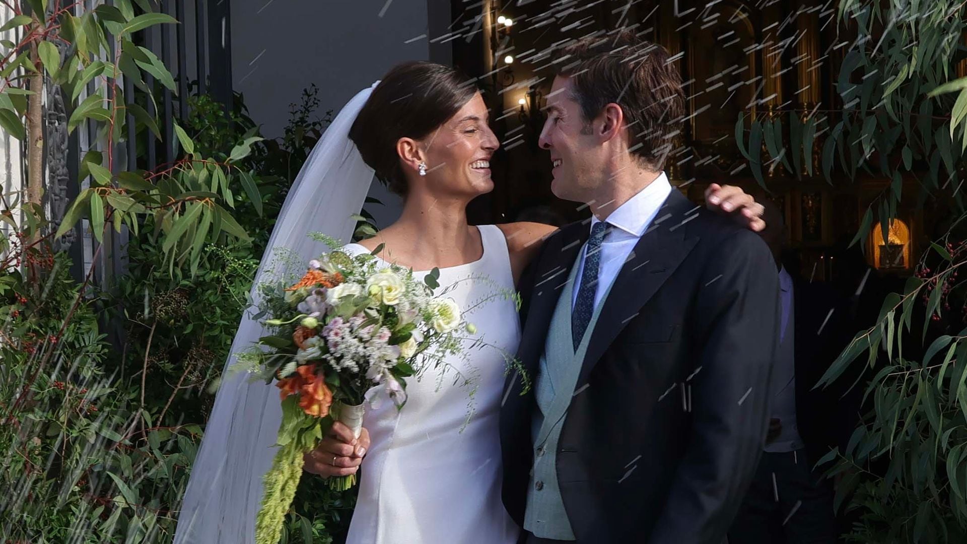 Victoria y Rafael, ya convertidos en marido y mujer, reciben muy sonrientes una lluvia de arroz a las puertas del templo