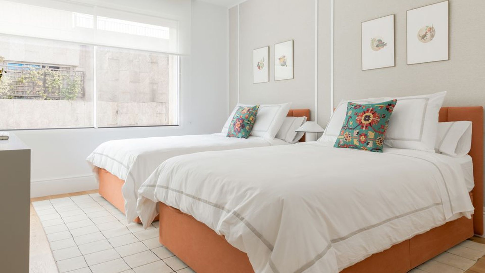 Dormitorio de dos camas en blanco y naranja