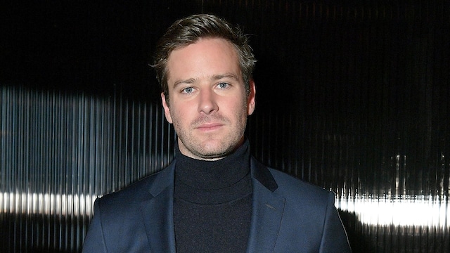 Plano medio de Armie Hammer en un evento con traje azul marino