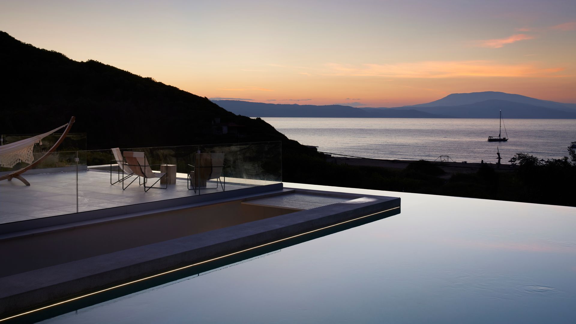 Piscina infinita de noche con vistas al mar 