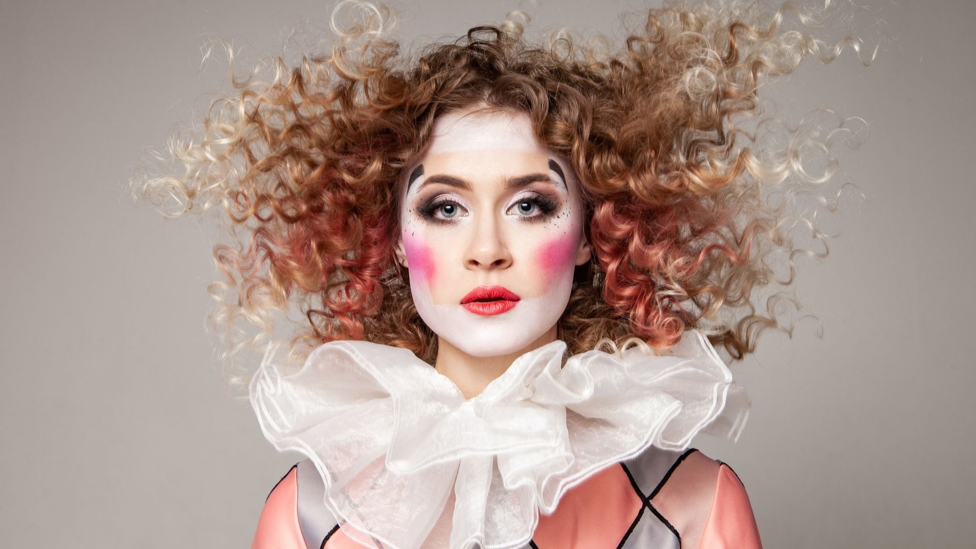 Mujer con maquillaje y disfraz de arlequín