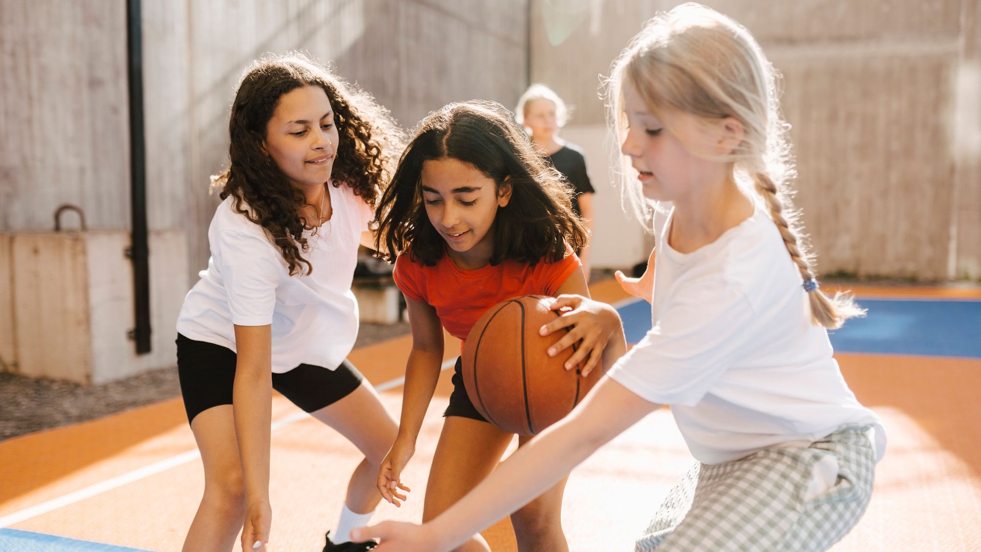 Niñas jugando al baloncesto en el patio del colegio.