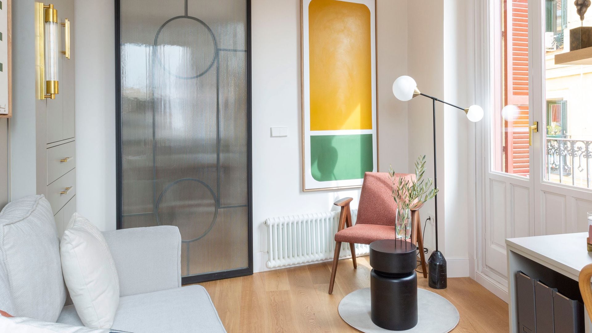 Lámpara de pie con pantallas de cristal opal junto a una butaca