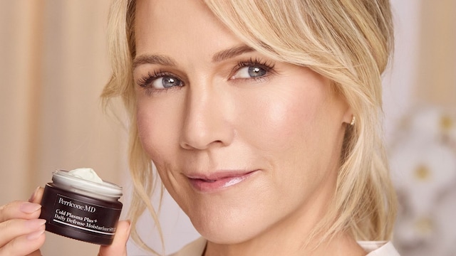 Rostro de mujer rubia con piel luminosa y crema de Perricone MD en la mano